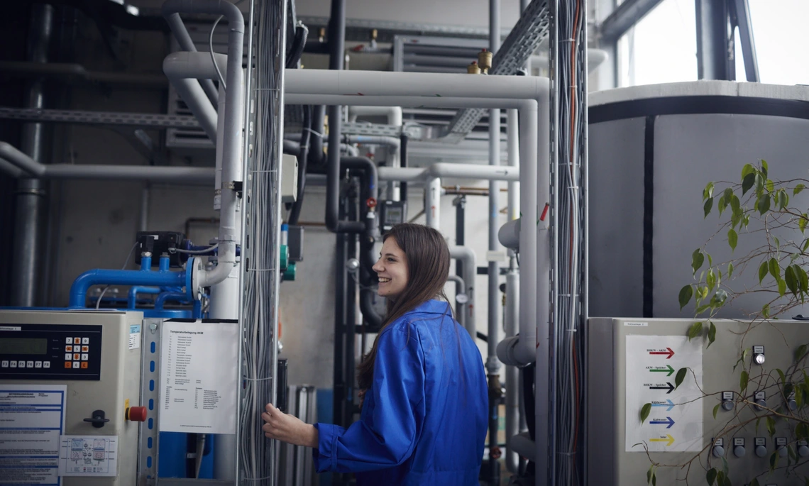 Labor_G313_C026_Waerme_Kaeltepumpe_THI Mitarbeiterin steht vor der Wärme-Kälte-Pumpe im Labor