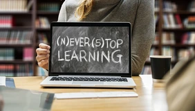 Der Campus für Weiterbildung stellt sich vor (Symbolfoto: Pixabay). Symbolbild mit Laptop und Person dahinter, Auf dem Bildschirm steht: (N)ever (S)top Learning
