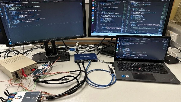 Image of a laptop and two monitors in the background